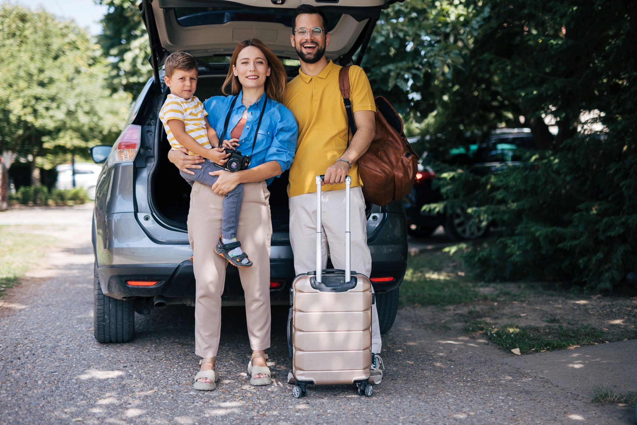 Family with luggage next to a car ready for travel