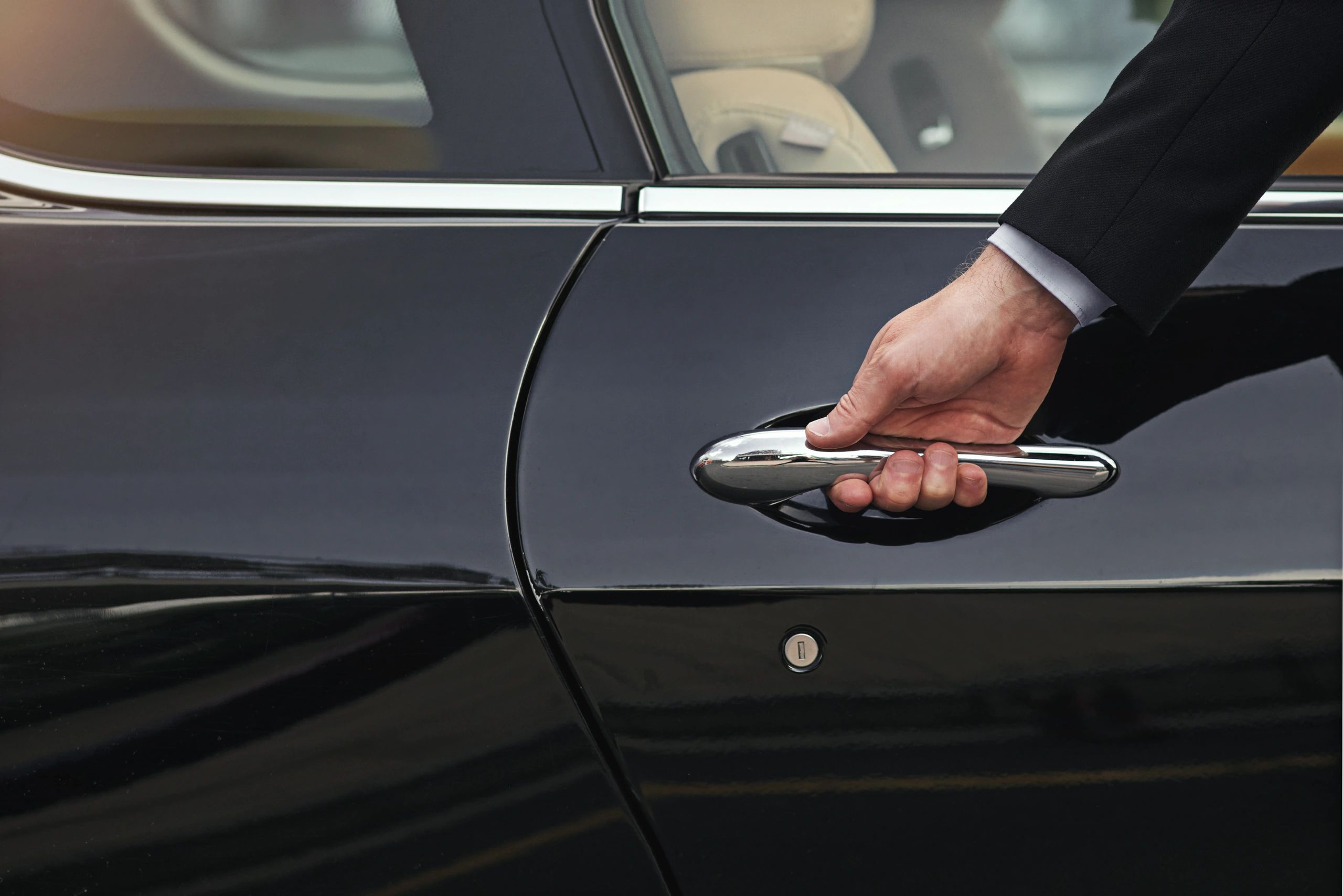Chauffeur opening a car door for a passenger